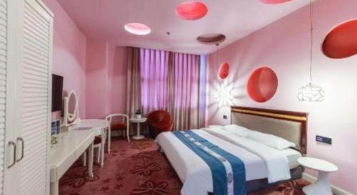 ein rosafarbenes Schlafzimmer mit einem Bett und einem Schreibtisch in der Unterkunft TO915101 STILL LOVE THEME HOTEL in Chengdu