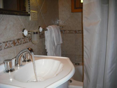 Un baño con lavabo y cortina de ducha. en Las Bahías, en Villa La Angostura