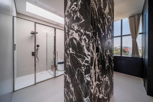 a bathroom with a black and white marble wall at Bangtao New Luxury 7 Bedrooms Modern Space Aesthetic Design Private Pool Villa Private Movie Theater in Ban Nong Chaeng