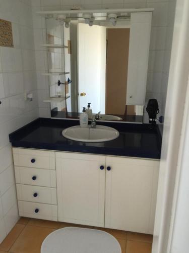 a bathroom with a sink and a mirror at Bahía Meloneras in Meloneras