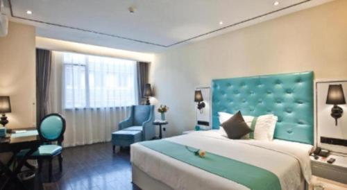 a bedroom with a large bed with a blue headboard at Xana Lite Leshan Haochi Street Branch in Leshan