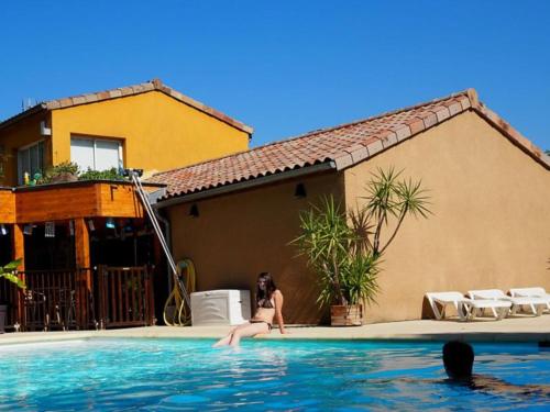 a woman in a bikini sitting in a swimming pool at Gîte confortable avec terrasse à Salavas - API-1-52-1143 in Vallon-Pont-dʼArc
