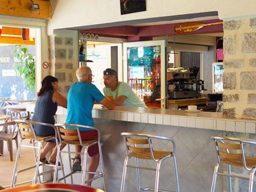 three people sitting at a bar in a restaurant at Gîte confortable avec terrasse à Salavas - API-1-52-1143 in Vallon-Pont-dʼArc
