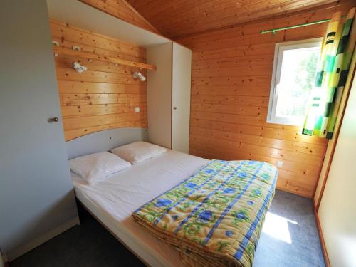 Chalet 40m² pour 6 personnes avec Terrasse - API-1-52-1154 في Charmes-sur-lʼHerbasse: غرفة نوم مع سرير في غرفة خشبية