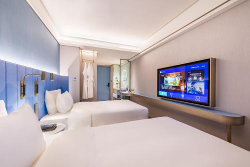 a hotel room with two beds and a flat screen tv at Beijing Tiananmen Square Manxin Hotel in Beijing