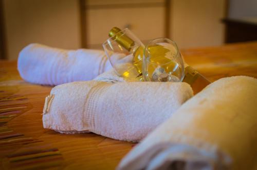 two rolled up towels with a glass of wine on a table at Dionos Villa with Jacuzzi in Asos