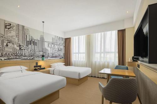 ein Hotelzimmer mit zwei Betten und einem Fernseher in der Unterkunft City Comfort Inn Shantou Tianshan Road Xinyicheng in Xialian