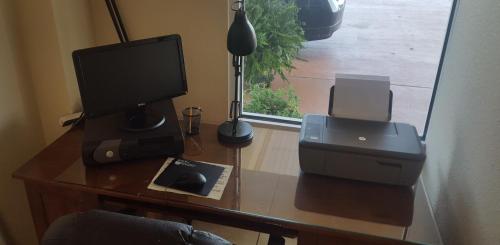 a desk with a computer monitor and a printer on it at The Rutledge Inn in Luverne