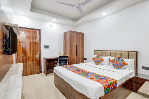 FabHotel Groom Room في نويدا: غرفة نوم بها سرير كبير وتلفزيون