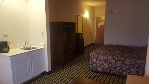 a hotel room with a bed and a sink at The Rutledge Inn in Luverne