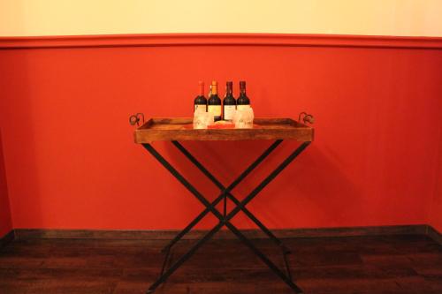 three bottles of wine sitting on a table against a red wall at Hotel Don Carlo in Broni