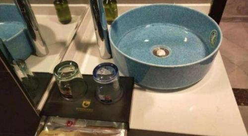 Ein Waschbecken mit einer blauen Schüssel auf einer Arbeitsplatte in der Unterkunft City 118 Selected Hotel Xi'an Fengcheng Nan Road in Xi'an