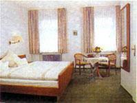 a hotel room with two beds and a table at Gasthof Anker in Miltenberg