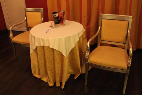 a table and two chairs with a white table cloth on it at Hotel Don Carlo in Broni