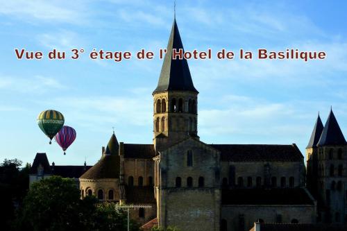 an old building with a hot air balloon in the sky at Hotel de la Basilique in Paray-le-Monial