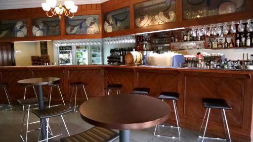a kitchen with a bar and a table with glasses on it at Mercure Port of Echuca in Echuca