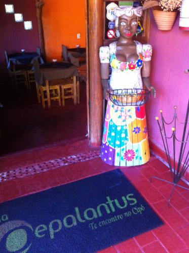 a figurine of a woman in a dress standing in a doorway at Pousada Pepalantus in Serra do Cipo