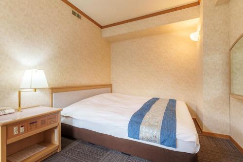 a small bedroom with a bed and a night stand at Hotel KOYO Bekkan - Vacation STAY 37061v in Hashima