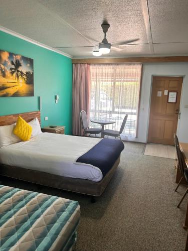 a hotel room with a bed and a table at Acacia Rose Motor Inn in Barham