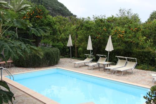 una piscina con sillas, mesas y sombrillas en Villa Flavia, en Sant'Agnello