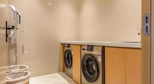 a laundry room with a washing machine and a counter at City Comfort Inn Lhasa Gongga County Gongga Airport in Zamsar
