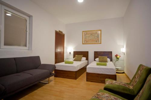 a living room with two beds and a couch at Marco Polo Party Hostel in St. Julianʼs