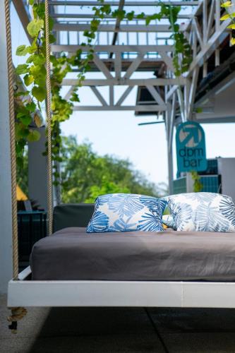 a bed with blue and white pillows on it at DPM Koh Tao Diving Hotel & Bar in Ko Tao