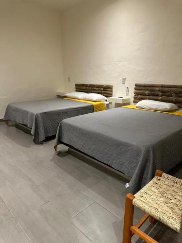 two beds sitting next to each other in a room at Hotel Monte Ixk'al Xilitla in Xilitla