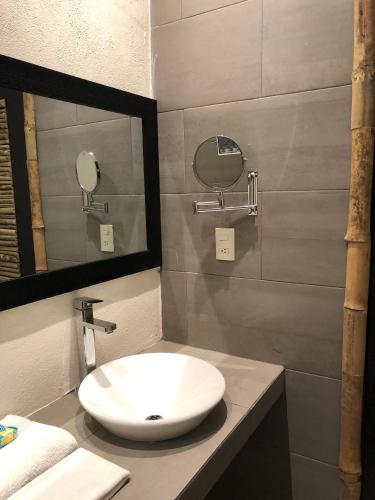 a bathroom with a white sink and a mirror at Hotel Monte Ixk'al Xilitla in Xilitla