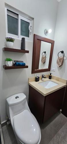 a bathroom with a white toilet and a sink at Casa Úcu en La Paz, BCS in La Paz