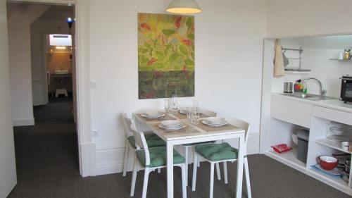 a dining room table with chairs and a painting on the wall at Koolhouse Porto in Porto