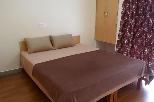 uma pequena cama num quarto com uma cortina em LVMR RIDER REST Homestay em Kulu