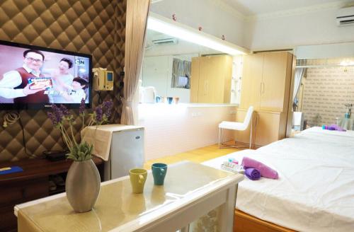 ein Zimmer mit einem Bett und einem Fernseher an der Wand in der Unterkunft Ximen NIANIA in Taipeh