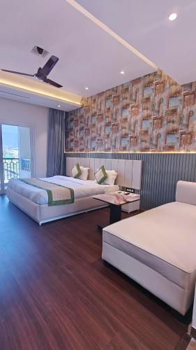 a bedroom with two beds and a wall with a painting at Hotel Livbox in Dehradun