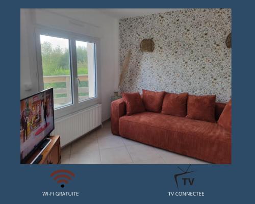 Una sala de estar con un sofá rojo y un televisor. en Belle maison proche de la mer, en Wimille