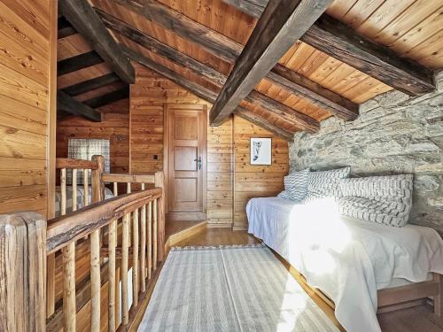 een slaapkamer in een blokhut met een bed en een trap bij PO Petite Ourses Suite - Anzere Slopeside - Swiss Alp in Anzère