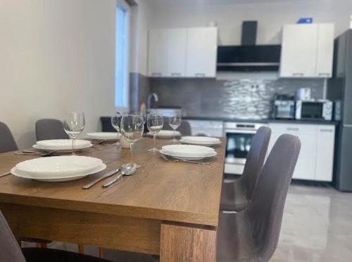 un tavolo di legno con sopra piatti e bicchieri da vino di TWIN Garden a Zánka