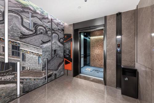 a elevator lobby with a mural of a building at Fromk Huankai Hotel Guangzhou Zhengjia Square Tiyuxi Road Metro stop Branch in Guangzhou