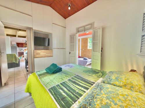 1 dormitorio con 1 cama grande y edredón verde en Appt T3 - Bourg de Sainte Anne, en Sainte-Anne