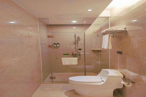 a bathroom with a toilet and a glass shower at Vienna Hotel Guangxi Hechi Jinchengjiang Baima Street in Hechi