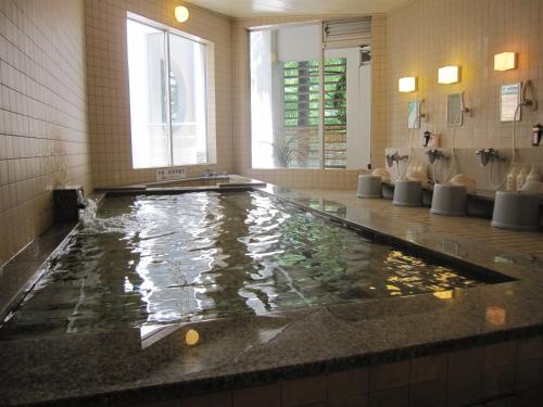 a bathroom with a large pool of water in a bath tub at Panorama Inn Yamanakako in Yamanakako