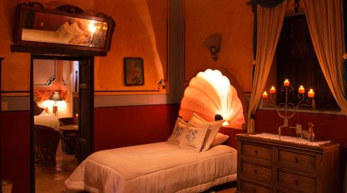 a room with a bedroom with a bed and a dresser at La Casona Minera in Mineral de Pozos