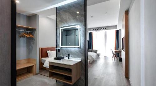 ein Badezimmer mit Waschbecken und Spiegel in der Unterkunft Borrman Hotel Jiangyin Zhouzhuang in Xiwujieqiao