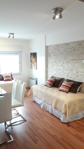 ein Schlafzimmer mit zwei Betten und einer Ziegelwand in der Unterkunft Caronti Suites in Bahía Blanca