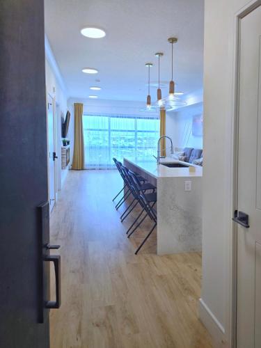 a kitchen and living room with a table and a dining room at Family Modern 1BR and Den Condo - Apartment with City View, Downtown, Balcony, Free Parking & In-Suite Laundry! in Calgary