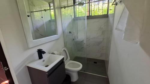 Un baño con inodoro, lavabo y ducha. en El Molino - Your perfect getaway awaits you here!, en Pamplonita