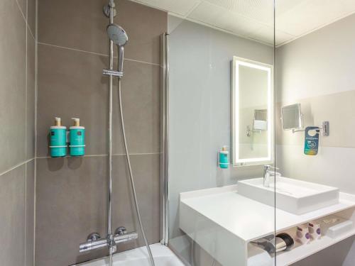 ein Badezimmer mit Dusche und Waschbecken in der Unterkunft Novotel Bourges in Bourges