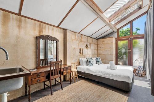 a bedroom with a bed and a sink and a mirror at Hidden Zen - A South Freo Retreat in South Fremantle
