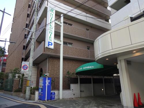 a building with a sign on the side of it at Hotel Koshien in Nishinomiya