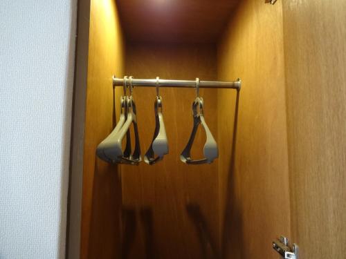 a bathroom with three hoses hanging from a door at Hotel Koshien in Nishinomiya